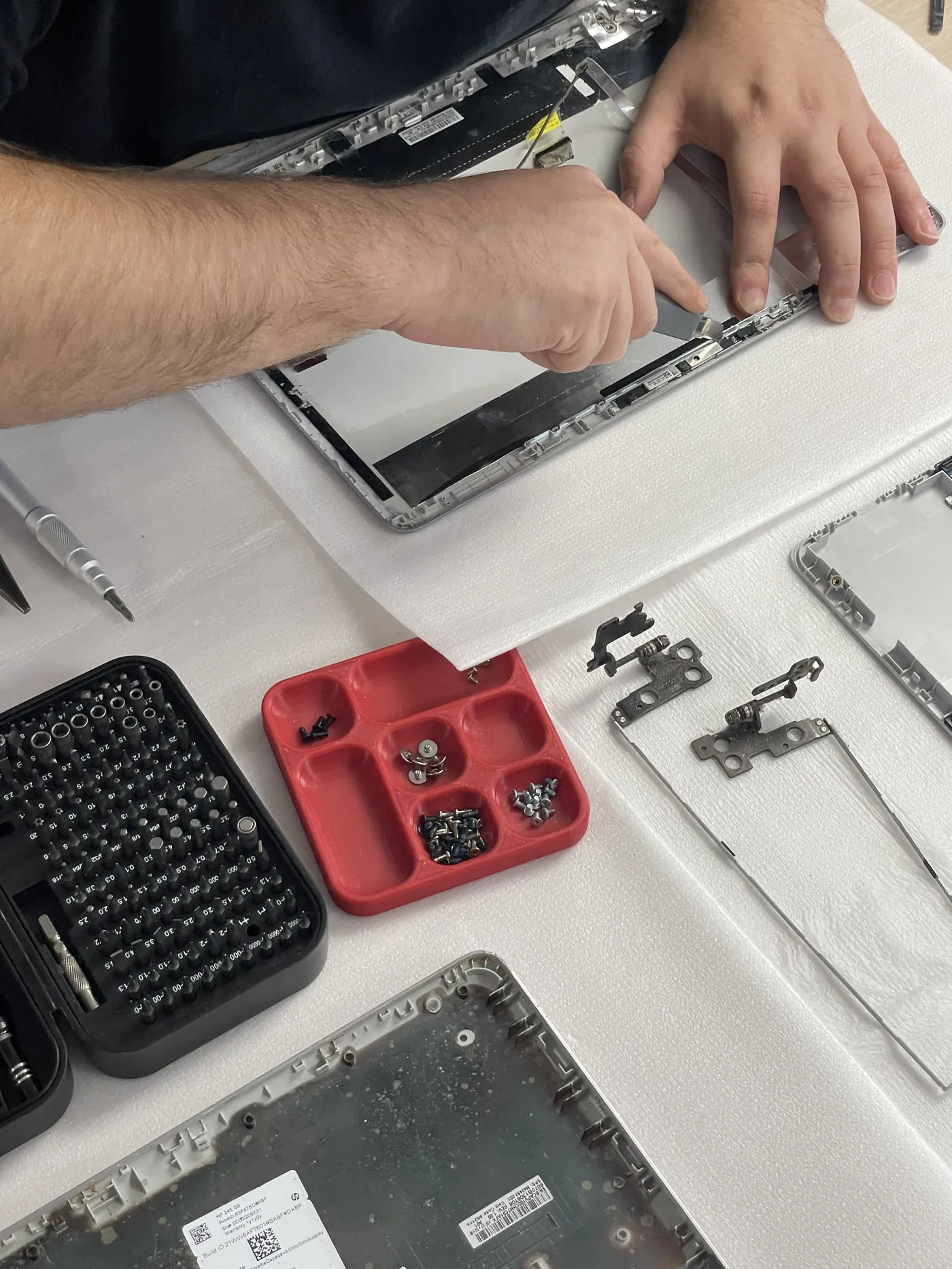 Technicien en train de remonter la dalle d’un ordinateur portable dans l’atelier Greenleo