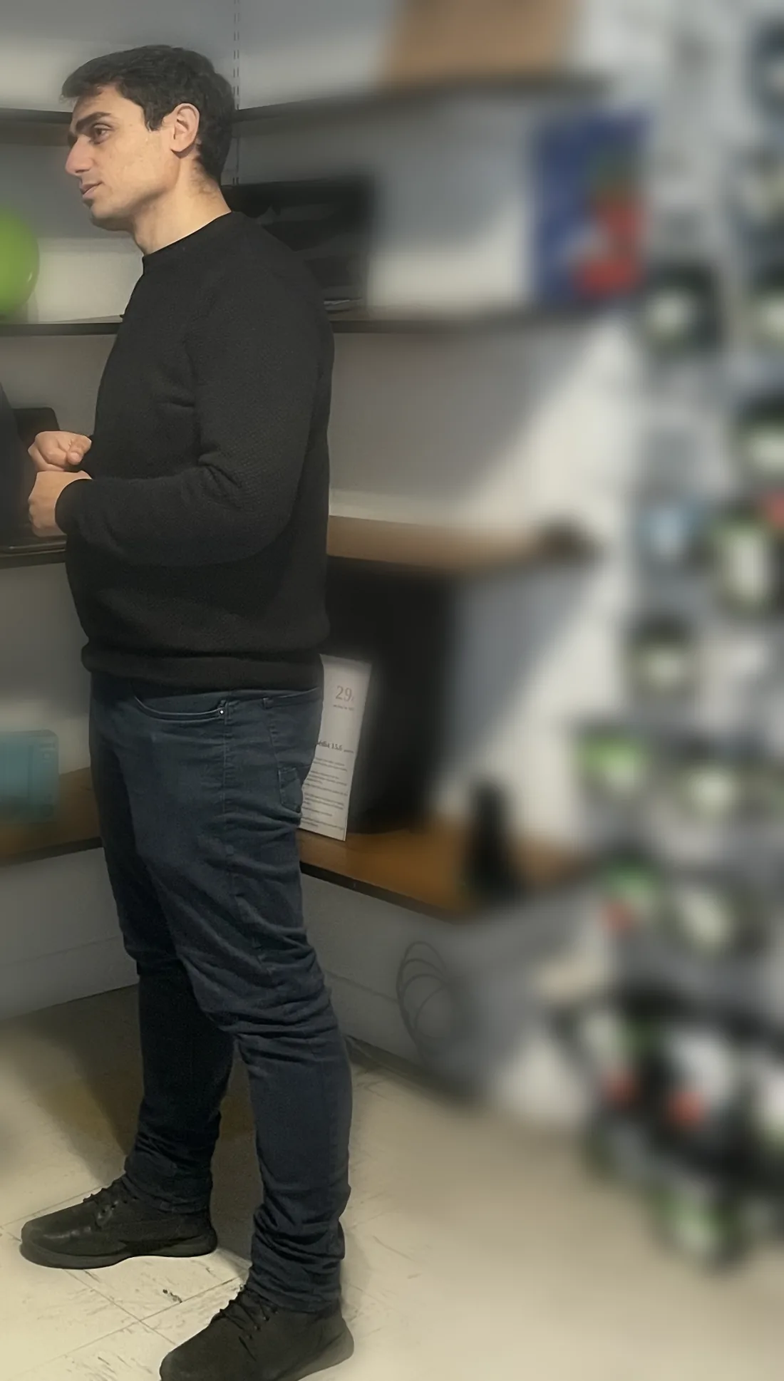 Un conseiller de la boutique PC@9 à Ingwiller devant les rayonnages